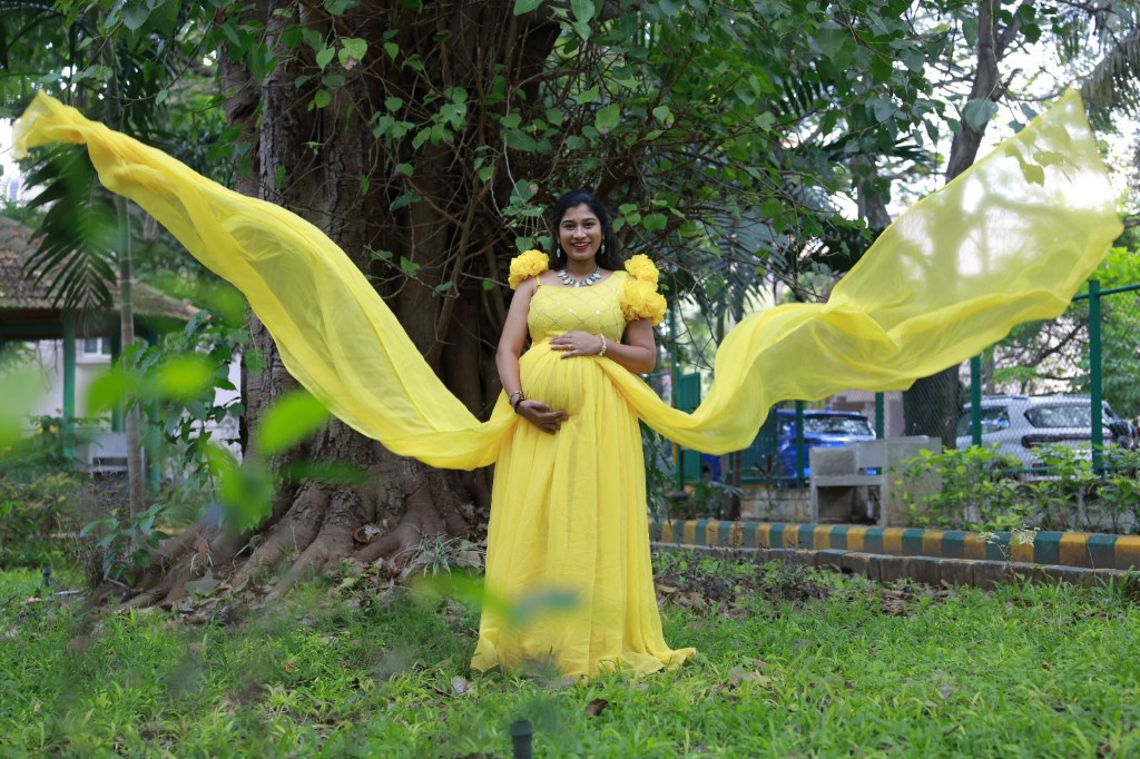 Maternity gown with flowing fabric outdoors, Usha Photo Studio