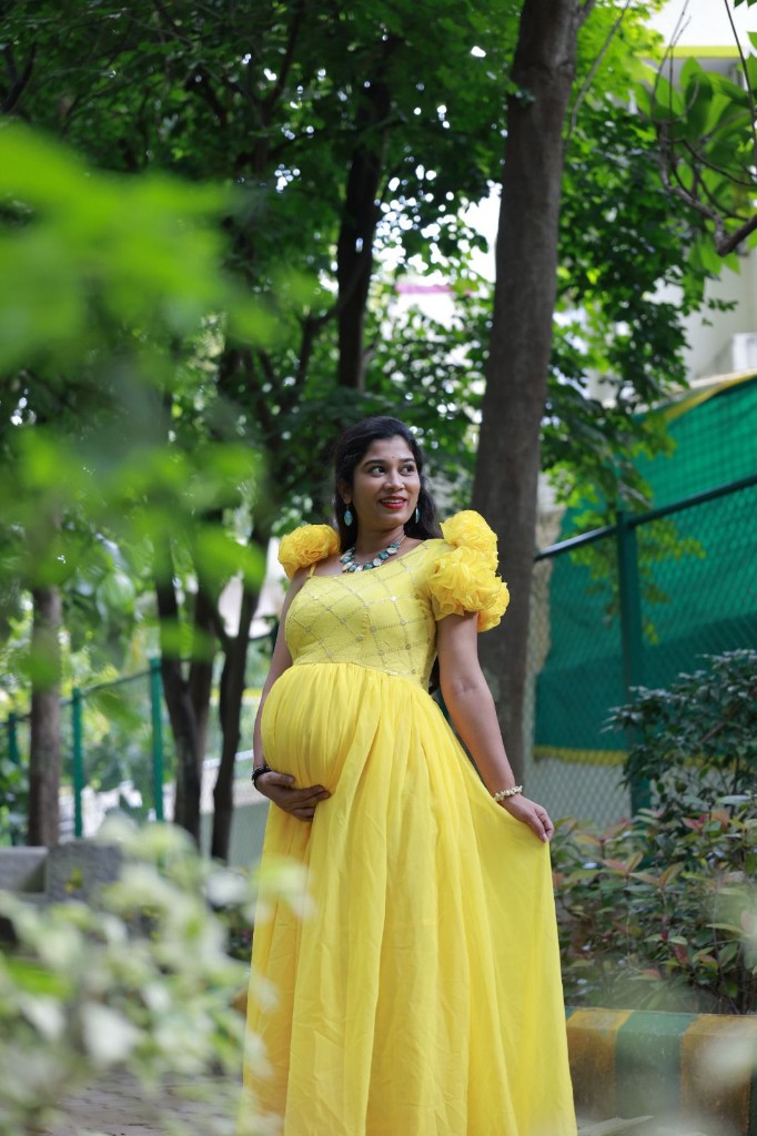Maternity photography in a yellow dress among garden greenery, Bengaluru